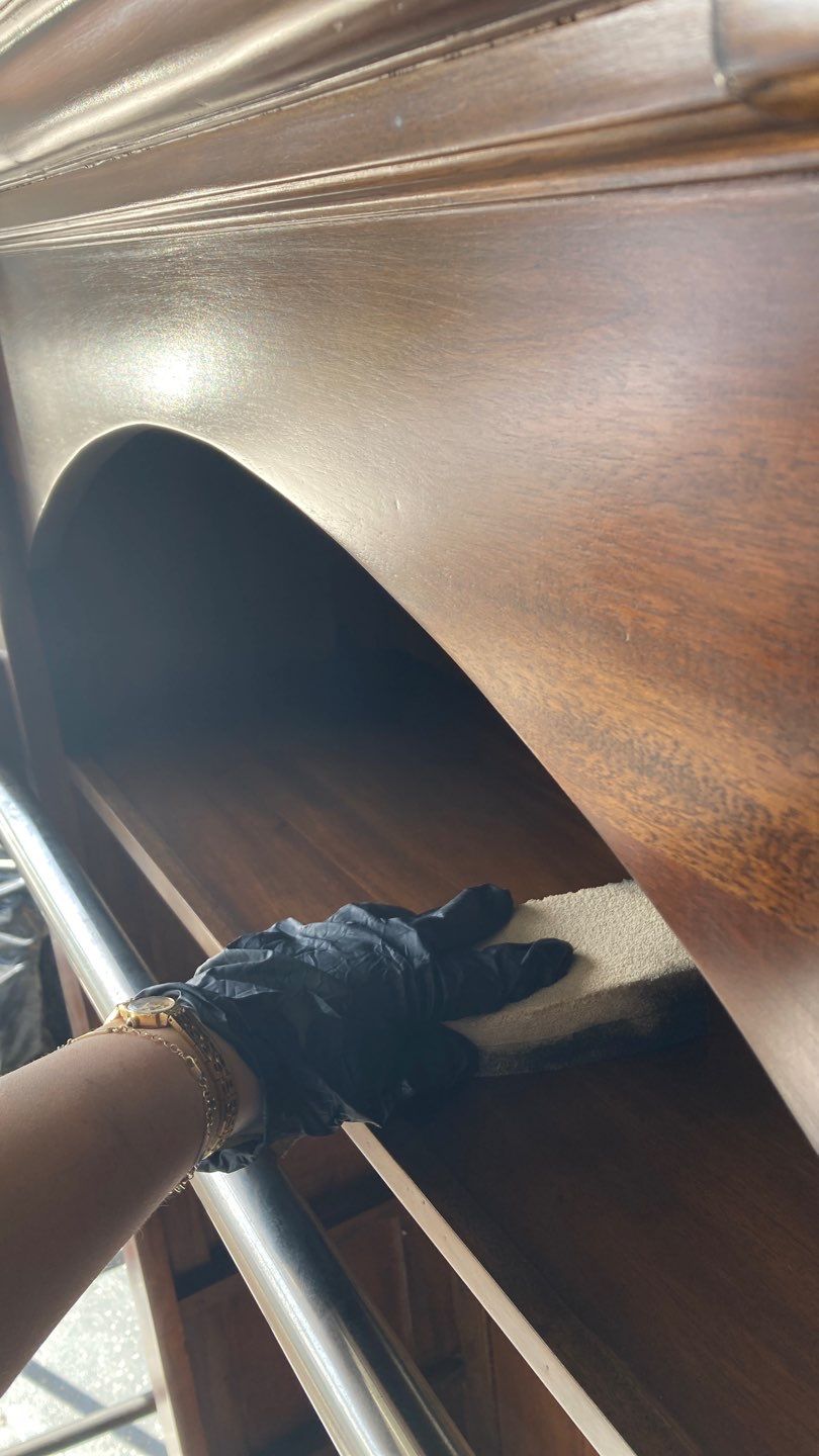 Technician in gloves wiping soot and smoke residue from wood furniture